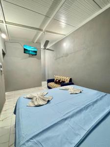 Un dormitorio con una cama azul y un sofá. en Hospedaje Ñande Roga, en Asunción