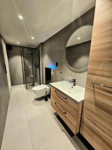 a bathroom with a sink and a toilet and a mirror at Fin 3-roms leilighet i Harstad sentrum in Harstad