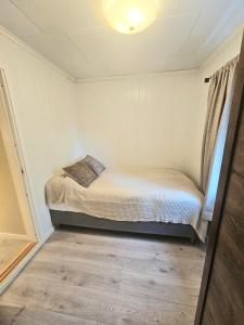 a small bedroom with a bed in a room at Fin 3-roms leilighet i Harstad sentrum in Harstad +1 photo