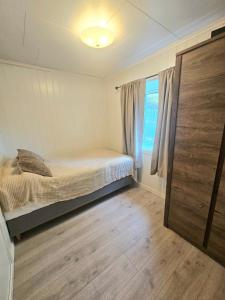 a bedroom with a bed and a window at Fin 3-roms leilighet i Harstad sentrum in Harstad