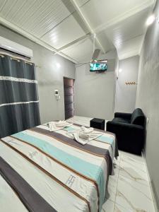 a room with a bed and a chair and a television at Hospedaje Paluma in Asunción