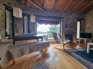 a living room with a bench and a large window at Stone View Nest - By Ski Alure in Arachova