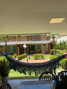 a hammock in the middle of a courtyard at Village 2 suítes beira mar Itacimirim in Camaçari