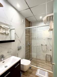 a bathroom with a shower and a toilet and a sink at Olympic Hotel in Parga +61 photos