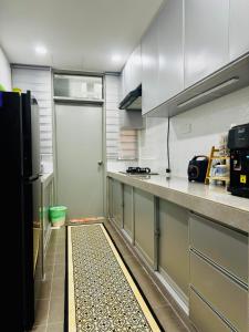 a kitchen with a door leading into a kitchen with a tile floor at Az homes AG in Kampong Jelatang