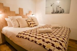 une chambre avec un grand lit avec une couverture à carreaux dans l'établissement Les Chalets de L'Aiguille C003, au Chinaillon