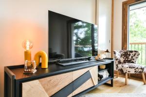 - un salon avec une commode et une télévision dans l'établissement Les Chalets de L'Aiguille C003, au Chinaillon