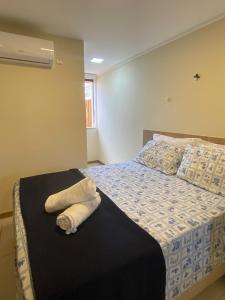 een slaapkamer met een bed met twee handdoeken erop bij Village 2 suítes beira mar Itacimirim in Camaçari