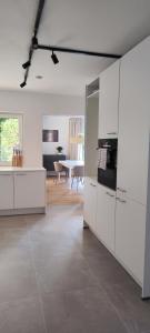 a kitchen with white cabinets and a living room at Storch Appartements Limburg in Hundsangen