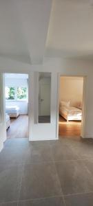 a white room with two beds and a tiled floor at Storch Appartements Limburg in Hundsangen