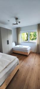 a bedroom with two beds and a large window at Storch Appartements Limburg in Hundsangen +2 photos