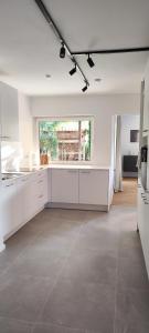 a kitchen with white cabinets and a large window at Storch Appartements Limburg in Hundsangen