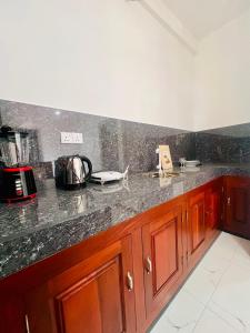 Una cocina con gabinetes de madera y encimera. en Blue Surf View - Tangalle, en Tangalle