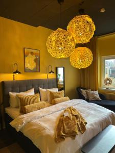 a bedroom with a large bed with yellow walls and lights at Hotell Onyxen, boutique- & lifestyle, Adults Only in Gothenburg