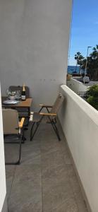 a balcony with two chairs and a table and a view of the ocean at Apartamentos playa Romanilla in Roquetas de Mar