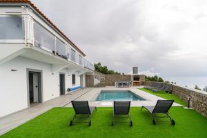 a house with a swimming pool and chairs on a lawn at Sunny Side I Free heated pool in Tábua