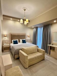 a large bedroom with a bed and a couch at Olympic Hotel in Parga