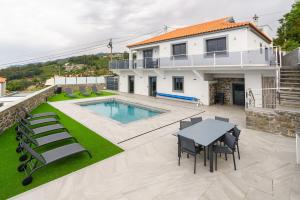a house with a pool and a table and chairs at Sunny Side I Free heated pool in Tábua