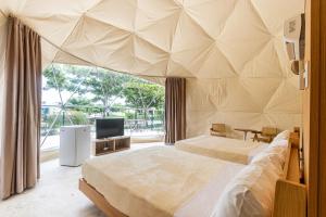 een grote slaapkamer met 2 bedden en een televisie bij Bubble Glamping 2 King beds, we have a 12 units like this in Laguna del Higüero