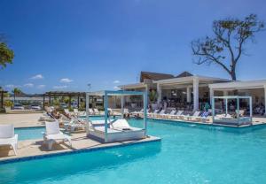 een resortzwembad met witte stoelen in het water bij Bubble Glamping 2 King beds, we have a 12 units like this in Laguna del Higüero