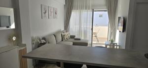 a living room with a couch and a table in front of a window at Apartamentos playa Romanilla in Roquetas de Mar