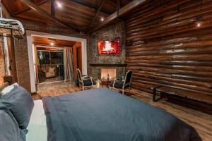 a bedroom with a bed in a room with wooden walls at Adorai Chalés in Piedade