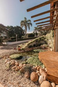 a garden with a pond and a wooden bench at Roteiros Adorai in Piedade