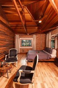 a bedroom with a bed and two chairs and a table at Roteiros Adorai in Piedade +80 photos