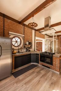 a kitchen with a brick wall and stainless steel appliances at Roteiros Adorai in Piedade