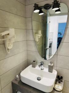a bathroom with a sink and a mirror at Gianna’s apartment central Aigio Cozy and Shining in Aígio +51 photos