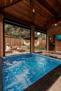 a swimming pool in a house with two people sitting at Roteiros Adorai in Piedade