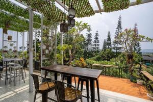 an outdoor patio with a wooden table and chairs at Seven Terrace in Caringin