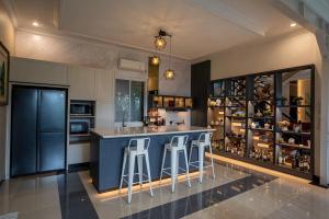 a kitchen with a blue bar with stools at Seven Terrace in Caringin