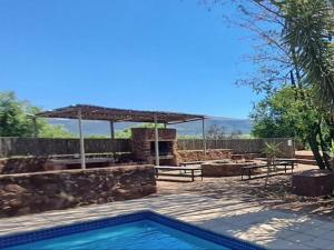 a swimming pool with a picnic table and a pavilion at Buck Hill Bush Lodge in Maanhaarrand