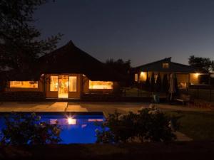 a house with a swimming pool at night at Buck Hill Bush Lodge in Maanhaarrand +17 photos