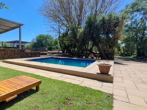 a small swimming pool in a yard with a bench at Buck Hill Bush Lodge in Maanhaarrand