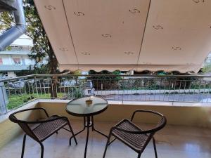 a balcony with two chairs and a glass table at Casa Napie Ioannina in Ioannina