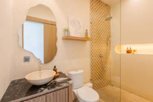 a bathroom with a sink and a toilet and a mirror at The Shalak Villa Bali in Denpasar +8 photos