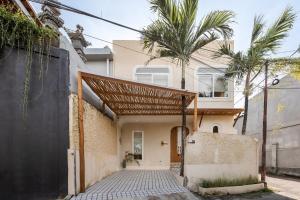 a house with awning and palm trees in front of it at The Shalak Villa Bali in Denpasar