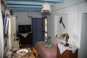a bedroom with a bed and a table and a blue door at Cavo Paradise Kimolos in Kimolos