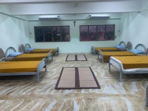 een kamer met rijen bedden en tafels erin bij Agnes Haven in Ban Khlong Haeng