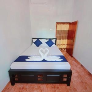two swans painted on a bed in a bedroom at Linu Villa in Hikkaduwa