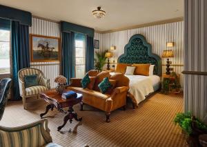 een slaapkamer met een bed, een bank en een stoel bij Brownsover Hall in Rugby