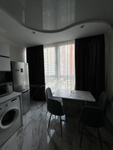 une cuisine avec une table et des chaises et un micro-ondes dans l'établissement Квартира с евроремонтом, à Odessa 2 autres photos