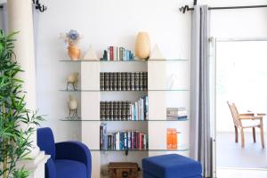 una sala de estar con sillas azules y estanterías en Casa do Sol Conscious Coliving, en Óbidos