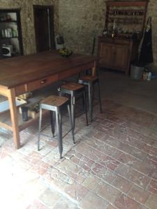 a wooden table and stools in a room at La Grande Gueronie in Saint-Sernin