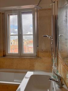 a bathroom with a sink and a window and a tub at Be Your Home - Cruise Stop Guest House in Civitavecchia