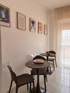two tables and chairs in a living room at Be Your Home - Cruise Stop Guest House in Civitavecchia +17 photos