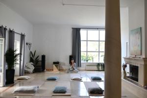 a woman sitting on the floor in a living room with meditation at Casa do Sol Wellness Home in Óbidos +70 photos