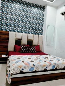 een slaapkamer met een groot bed met een muur bij Hotel Morning Star in Bathinda